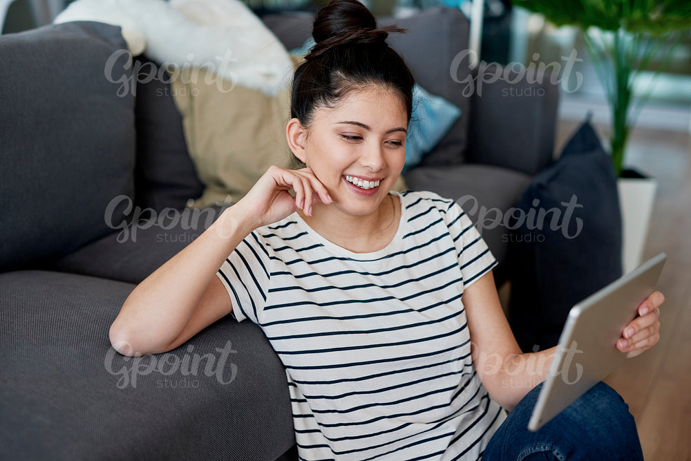 Young Asian woman watching something funny on the tablet.