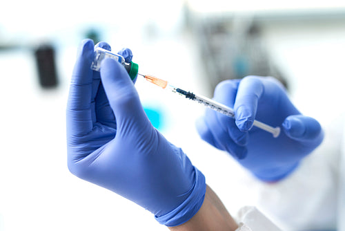 Syringe and vaccine in hands of a doctor