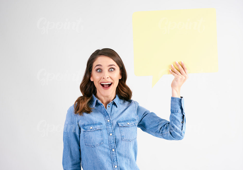 Surprised woman with speech bubble in studio shot