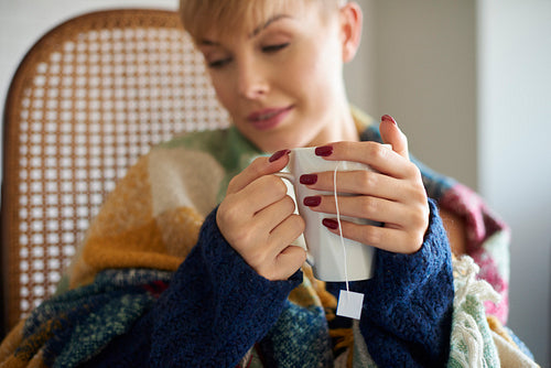 Woman's hand holding mug of hot tea