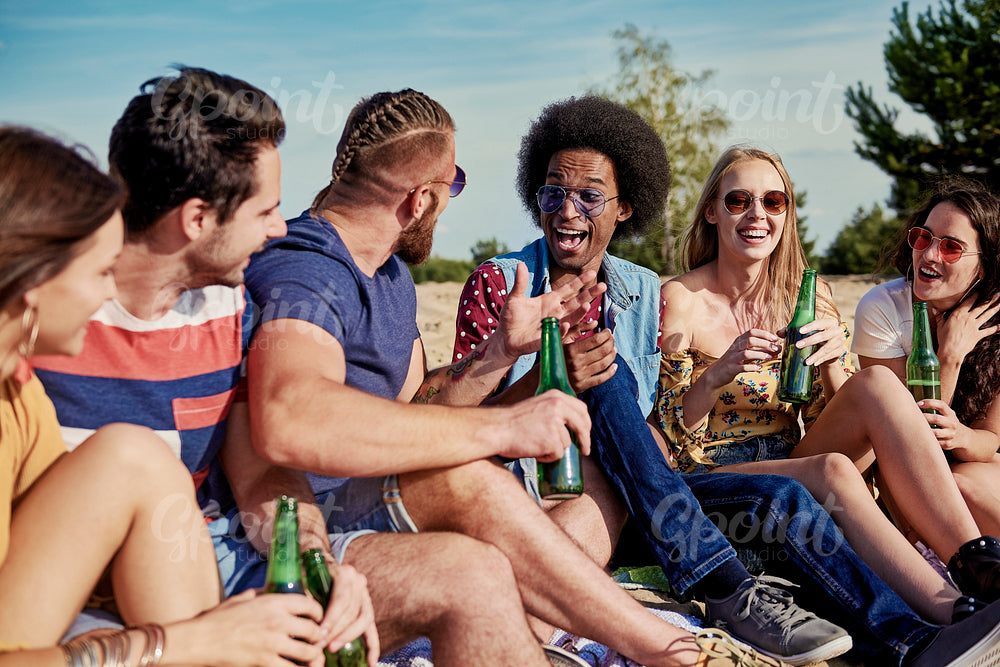 Six young people drinking beer outside