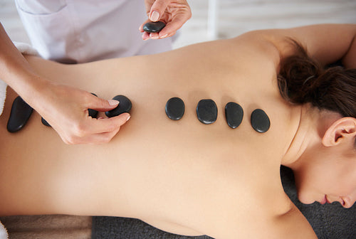 Massage of back by hot stones
