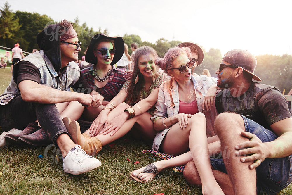 Friends sitting on the grass at music festival