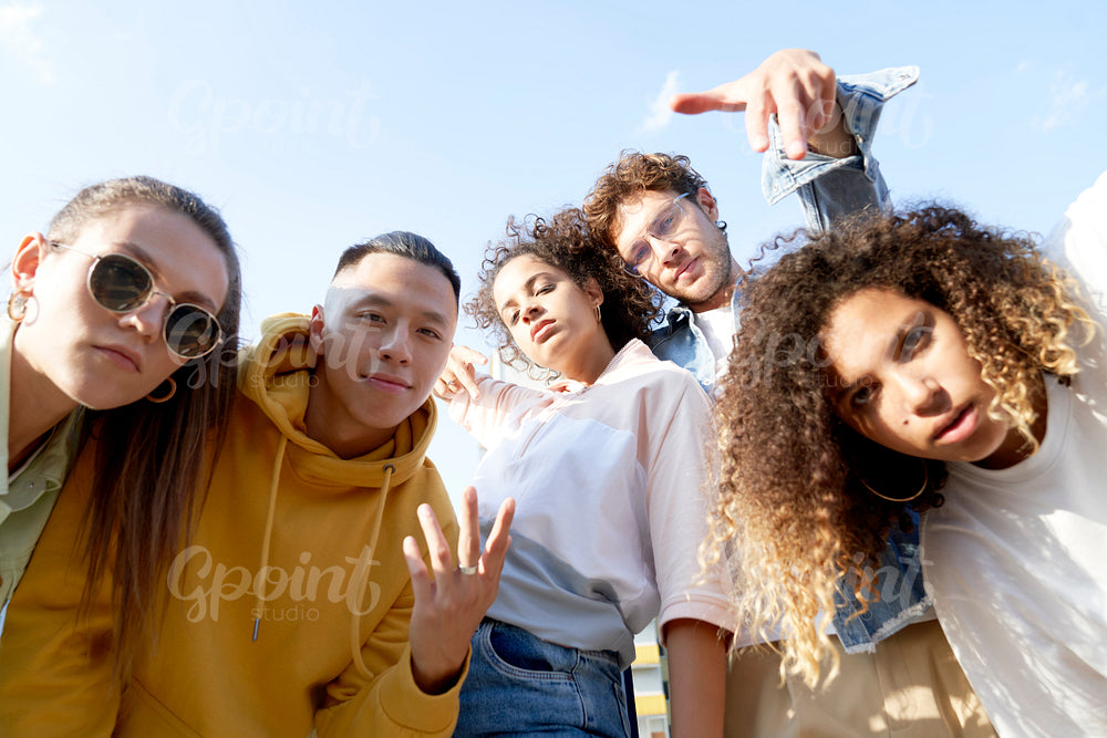 Bottom view of cheerful friends taking selfie outdoors
