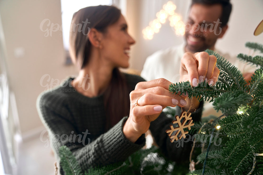Happy couple decorating Christmas tree at home 
