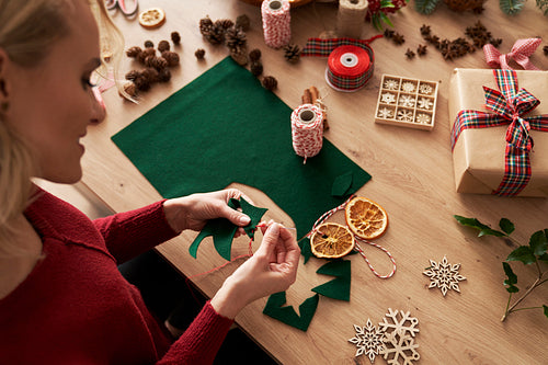 Top view of woman sewing Christmas ornaments
