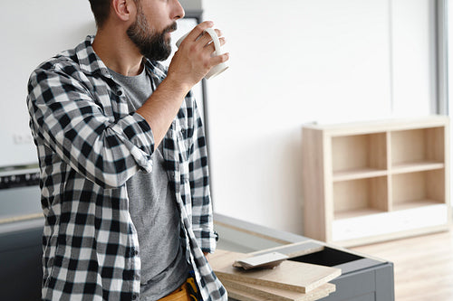 Unrecognizable man drinking cup of coffee during breaks in work