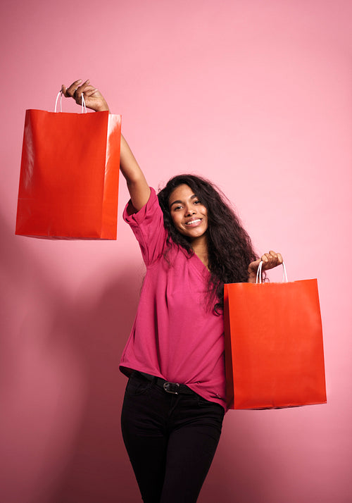 Portrait of smiling young African woman with shopping bags.