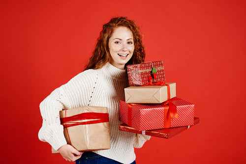 Portrait of happy girl holding stack of christmas present