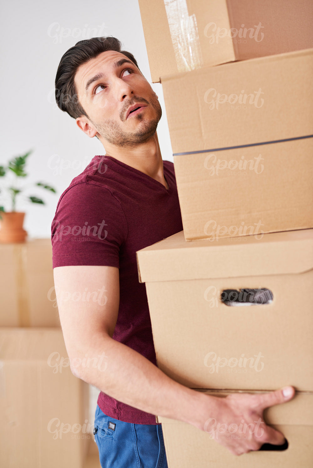 Stressed man carrying stack of cardboard boxes
