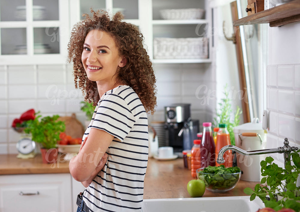Smiling young woman in her kitchen