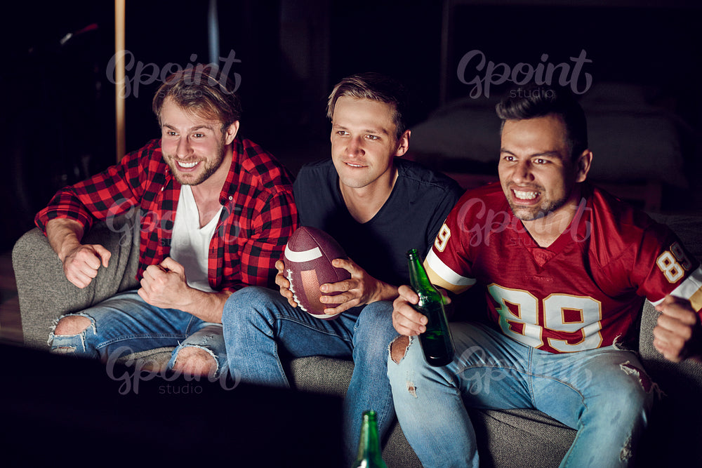 Stressed men watching match in concentration