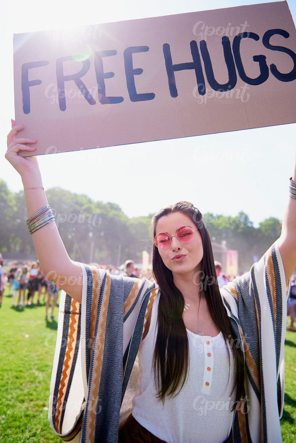 Portrait of young woman holding up free hug sign at festival