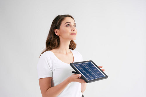 Young woman holding a model of solar panel