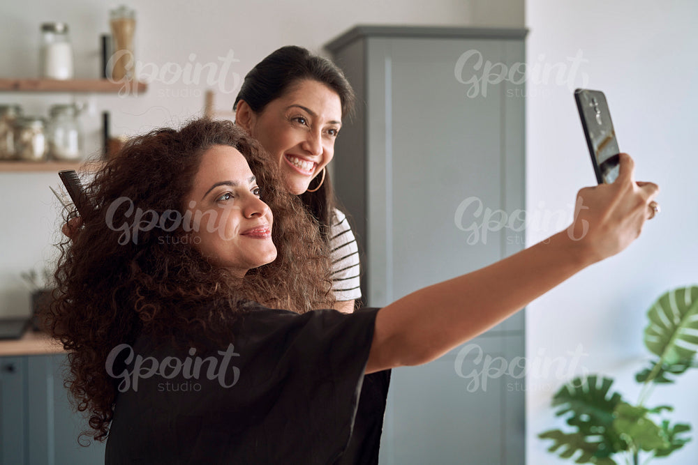 Smile women taking selfie while trimming their hair