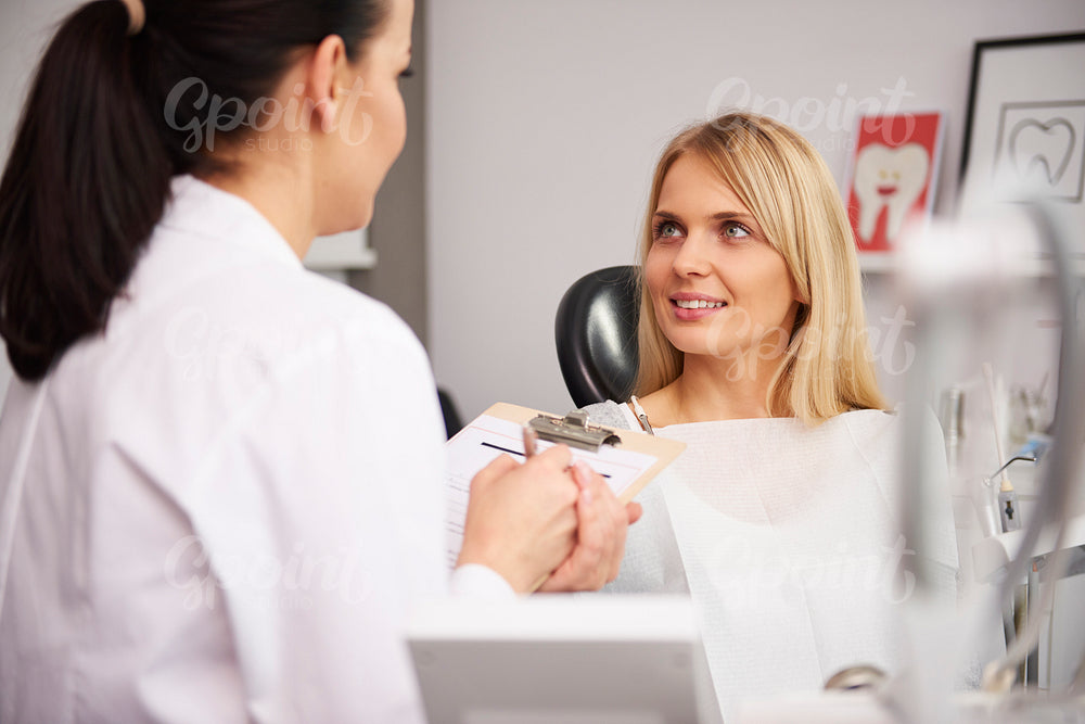 Dentist and patient discussing some medical record