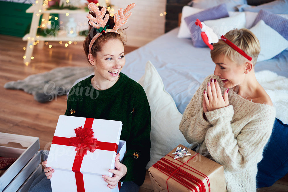 Excited girls opening christmas gift