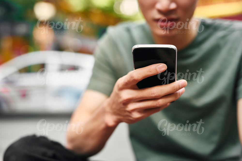 Close up of man using mobile phone in the city