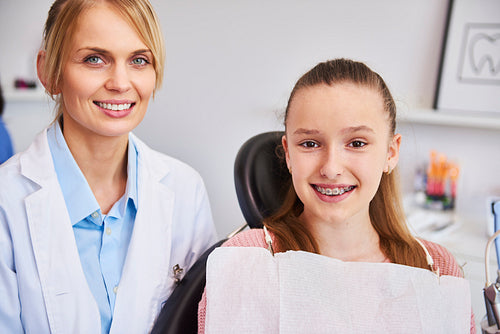 Smiling female orthodontist and child in dentist's office