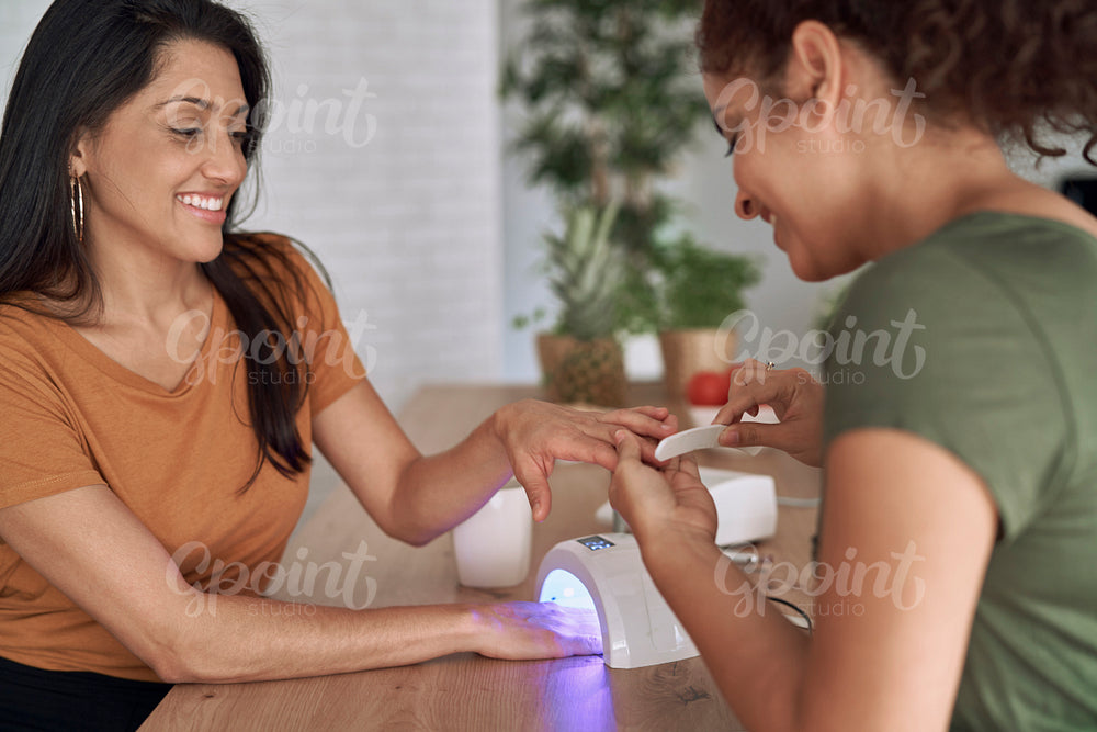 Two women making nail beauty treatments at home
