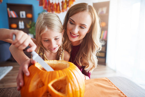 Mother and daughter making carved pumpkin