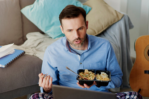 Man having lunch while video conference