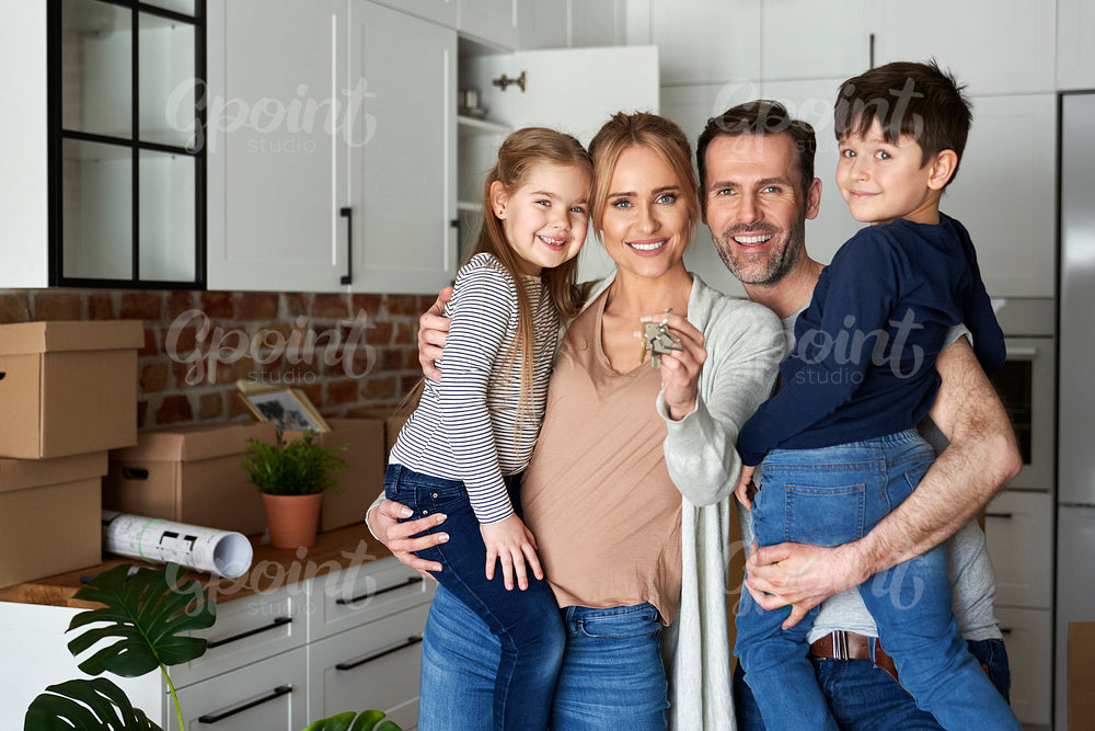 Portrait of family with children holding key for a new apartment