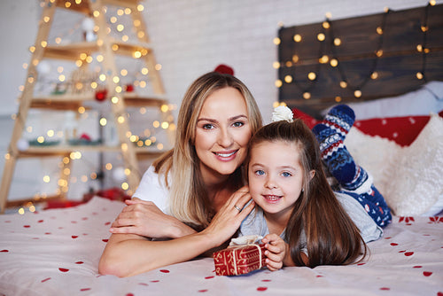 Portrait of mother and daughter with christmas present