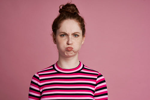 Studio shot of young woman with grimacing face