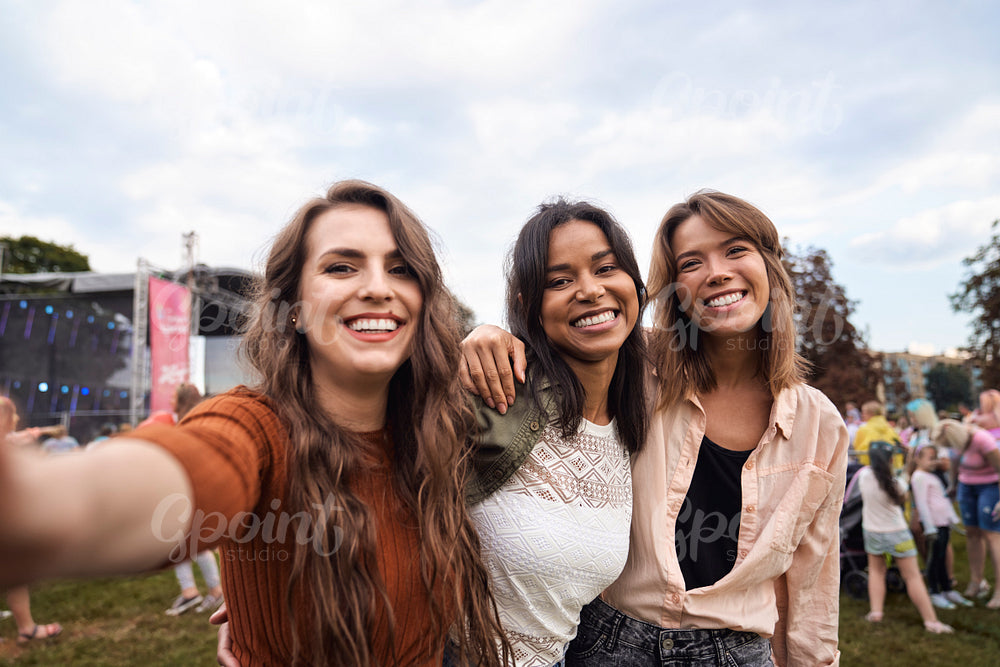 Group of friends making selfie at music festival 