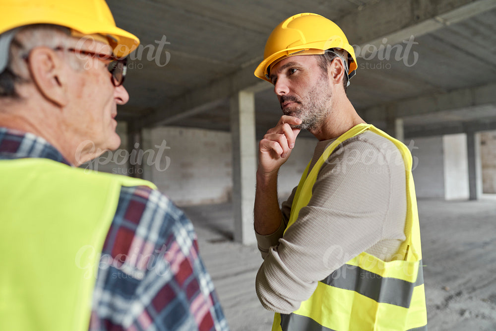 Back view of two caucasian engineers discussing on construction site   