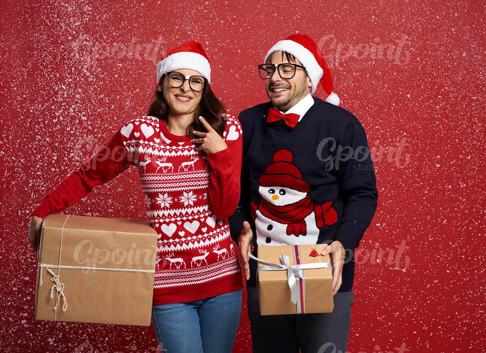 Couple in snowfall with Christmas present