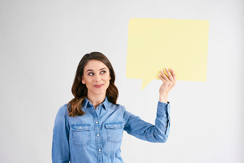 Young woman holding speech bubble with copy space