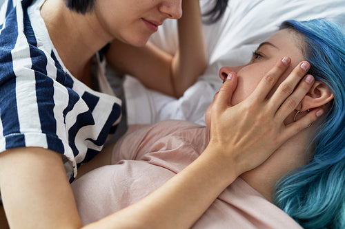 Close up of romantic lesbian couple lying on bed