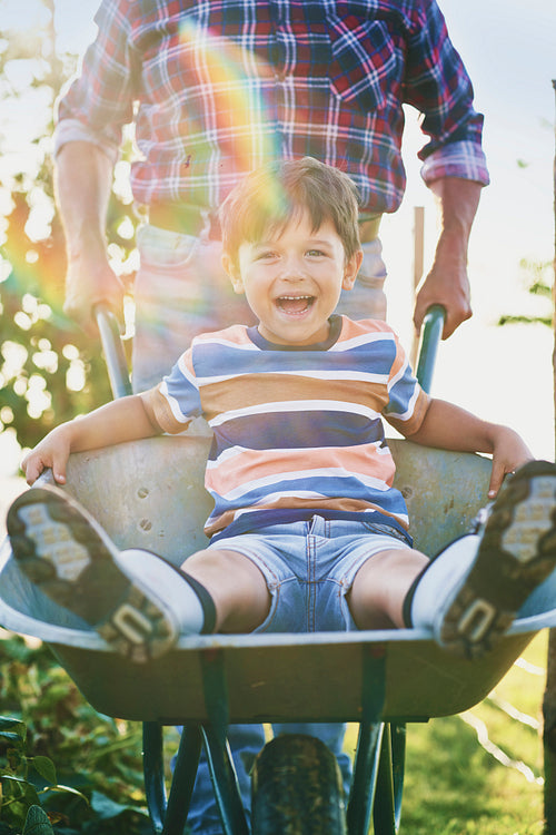 Front view of boy have fun while driving on wheelbarrows