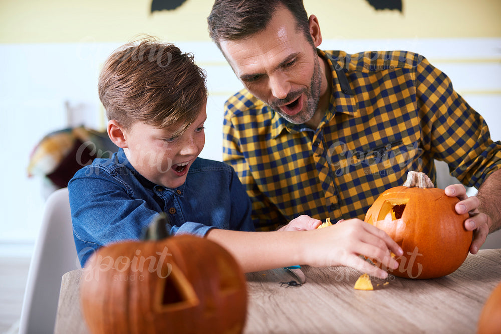 Father and son carving pumpkin