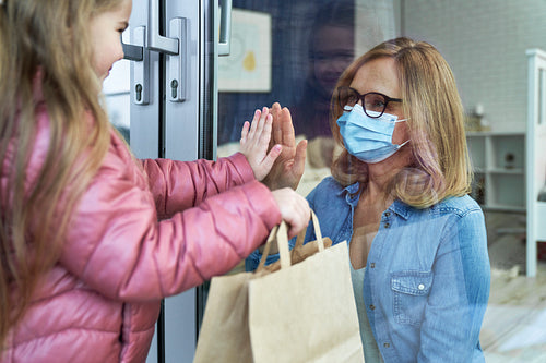 Little granddaughter giving grandma shopping during quarantine