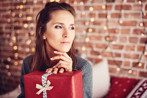 Woman with christmas present dreaming
