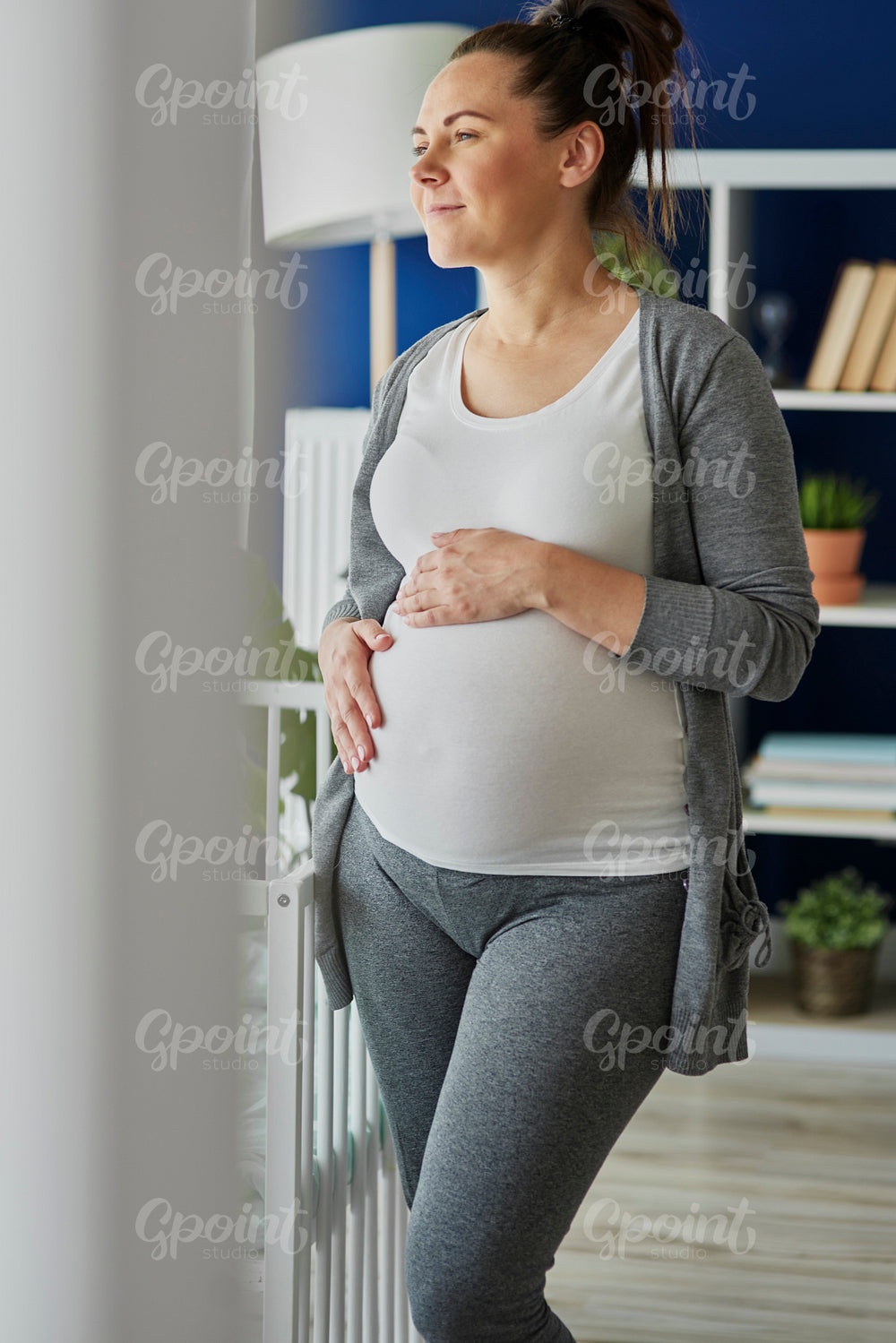 Vertical image of thoughtful pregnant woman indoors