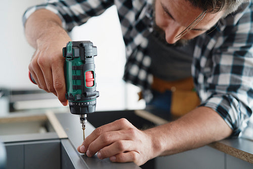 Close up of carpenter using a cordless drill