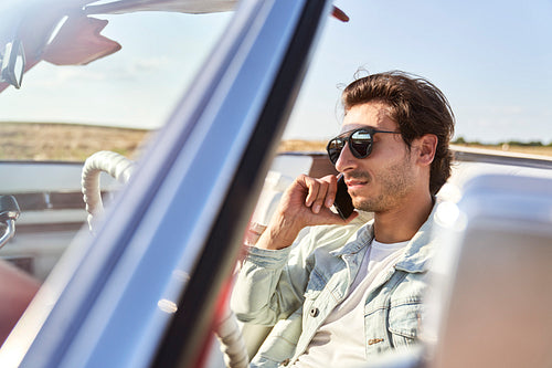 Close up of man talking on the phone in a car