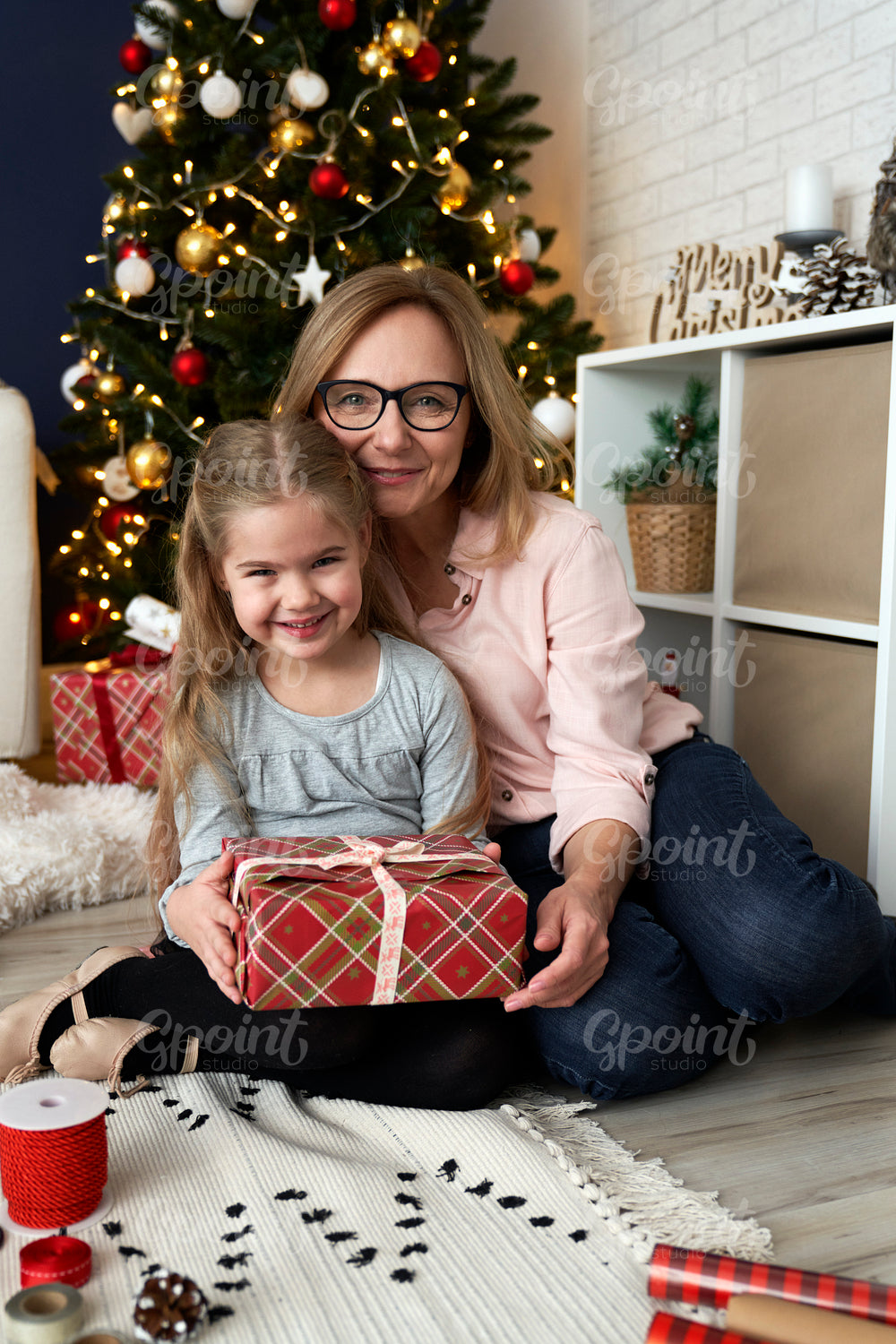 Portrait of grandmother and granddaughter embracing during the Christmas holidays.