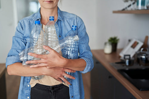 Woman carrying empty plastic bottles