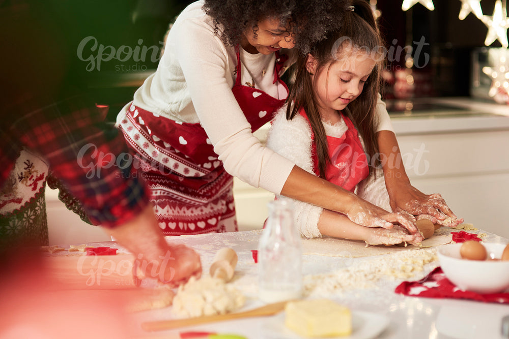 Girl making cookies with mom for Christmas