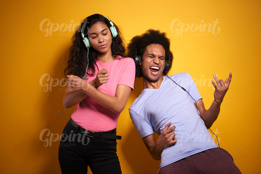 African couple listening to music and dances