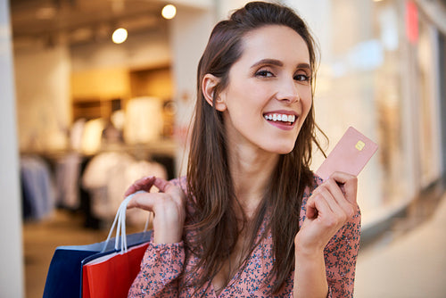 Portrait of smiling woman with credit card and shopping bags