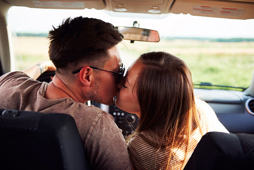 Loving couple kissing and embracing in a car