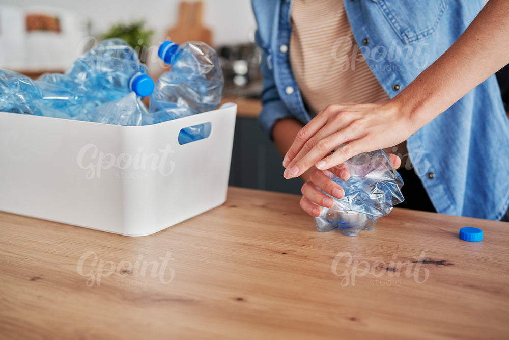 Close up of woman crushing plastic bottles
