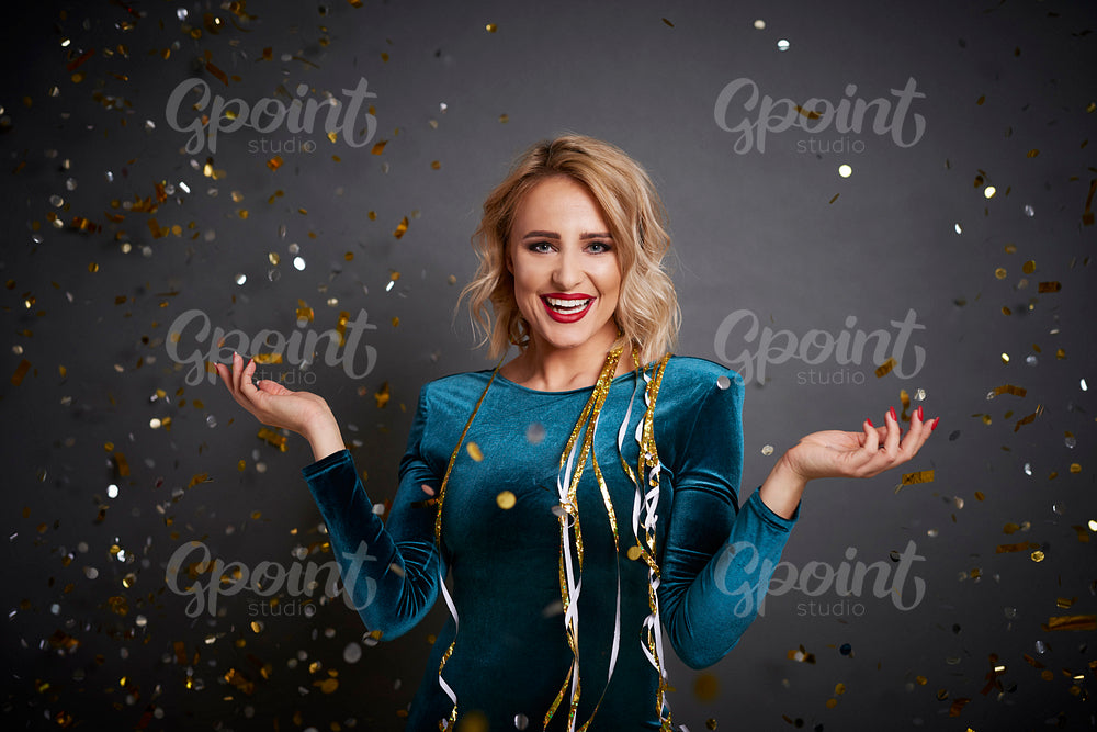 Woman holding something on her hand under shower of confetti