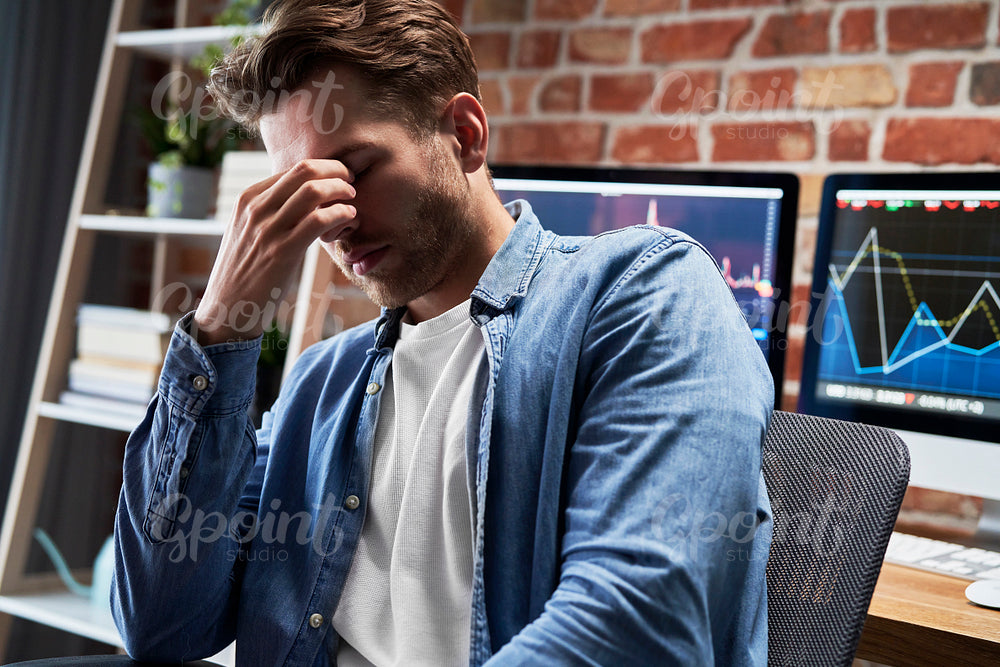 Young adult man is tired of work with finances 